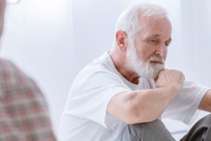 Sad Grey Senior Man Sitting On The Floor